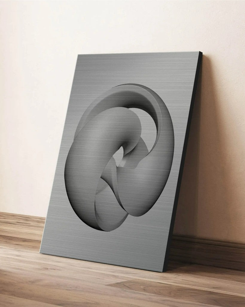 Brushed aluminium print leaning against a wall on a wooden floor