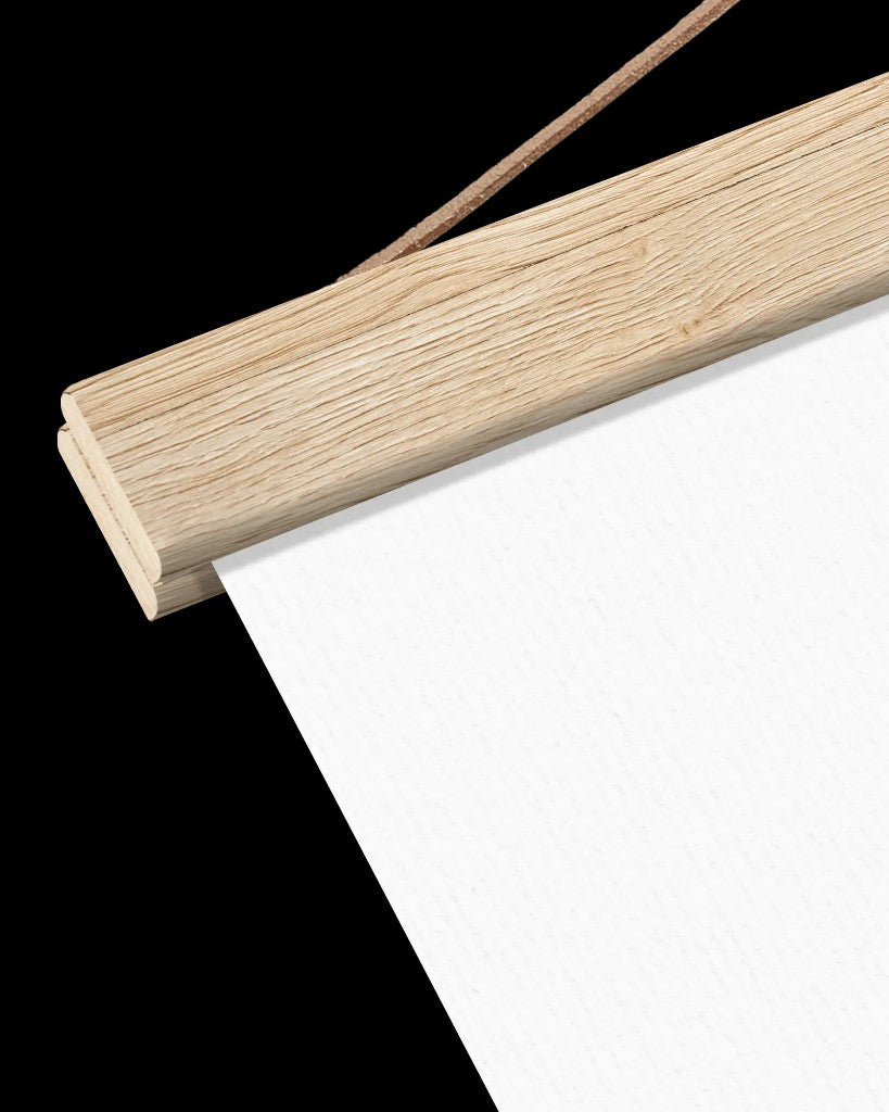 Close-up of magnetic wooden hanger bars holding textured white paper, with a hanging cord