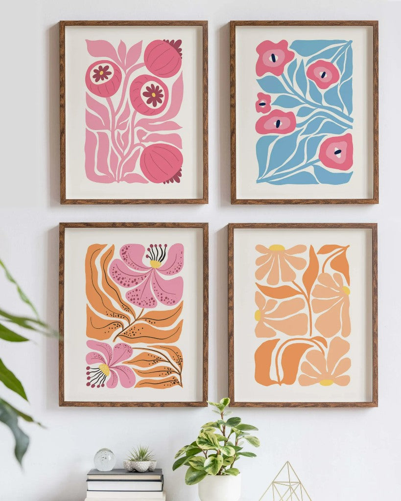 Four framed botanical posters in a two-by-two grid on a living-room wall